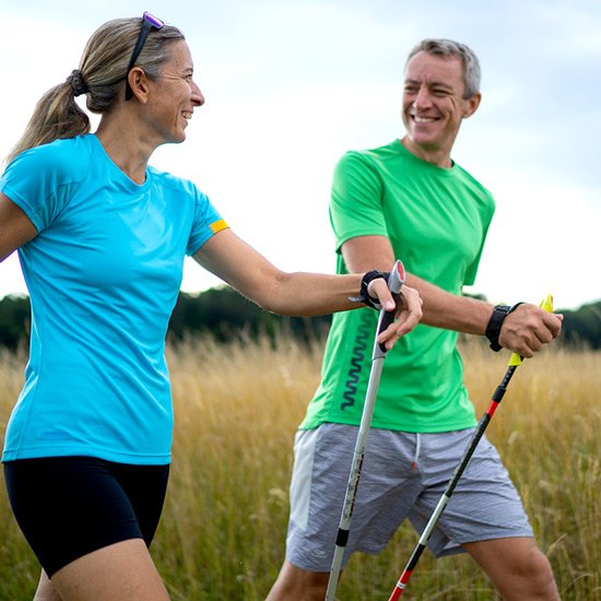 Bewegung hilft bei Müdigkeit Mann und Frau beim Nordic Walking