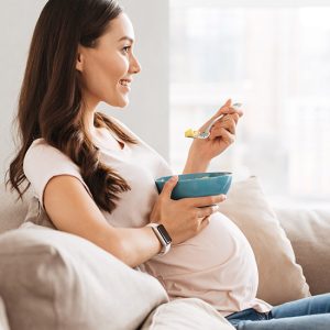 Jodzufuhr durch die Ernährung ist wichtig Schwangere Frau isst aus einer Schüssel