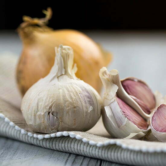 Knoblauch und Zwiebeln enthalten Schwefel Knoblauch und Zwiebel auf Küchentuch
