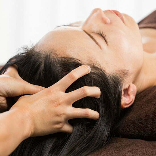 Kopfmassagen regen die Durchblutung an Frau bekommt eine Haarmassage