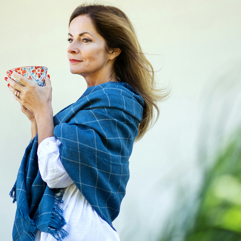 Frau mittleren Alters mit einer Tasse im Freien
